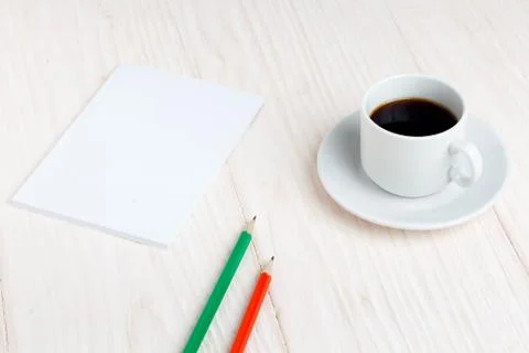 Cup of coffee, a notebook, pencils on the table Stock Photos