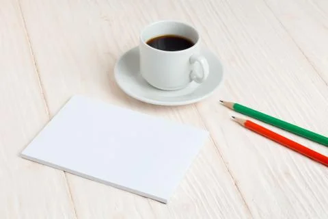 Cup of coffee, a notebook, pencils on the table Stock Photos