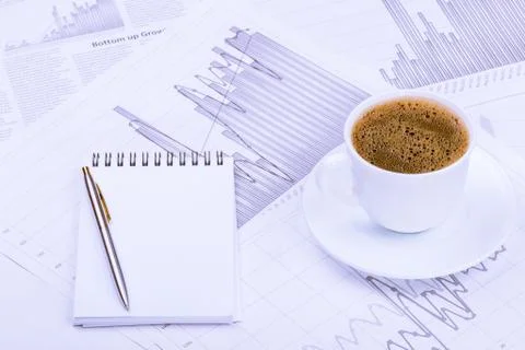 Cup of coffee, notepad  and graphs Stock Photos