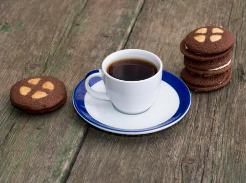 Cup of coffee on an old table decorated with cookies Stock Photos