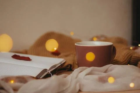 A Cup of coffee, an open diary on empty pages lie on the table, on which lies Stock Photos