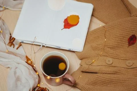 A Cup of coffee, an open diary on empty pages lie on the table, on which lies Stock Photos