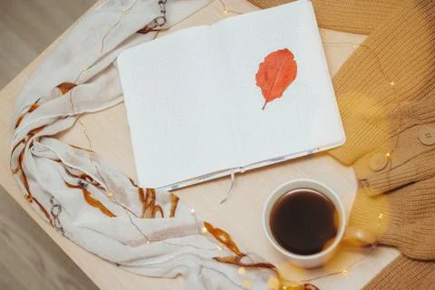 A Cup of coffee, an open diary on empty pages lie on the table, on which lies Stock Photos