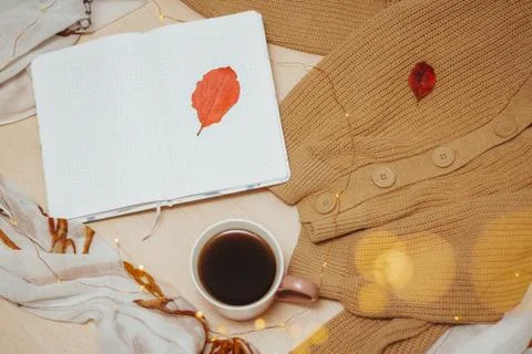 A Cup of coffee, an open diary on empty pages lie on the table, on which lies Stock Photos