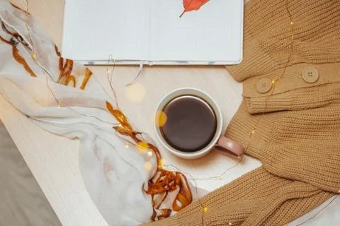 A Cup of coffee, an open diary on empty pages lie on the table, on which lies Stock Photos
