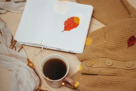 A Cup of coffee, an open diary on empty pages lie on the table, on which lies Stock Photos