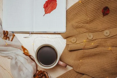 A Cup of coffee, an open diary on empty pages lie on the table, on which lies Stock Photos