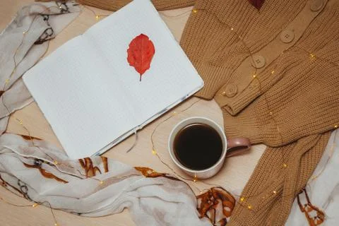 A Cup of coffee, an open diary on empty pages lie on the table, on which lies Stock Photos