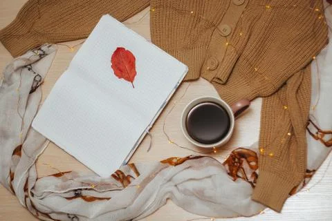 A Cup of coffee, an open diary on empty pages lie on the table, on which lies Stock Photos