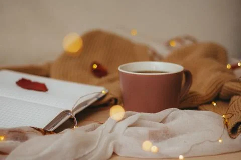 A Cup of coffee, an open diary on empty pages lie on the table, on which lies Stock Photos