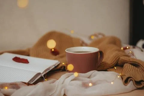 A Cup of coffee, an open diary on empty pages lie on the table, on which lies Stock Photos