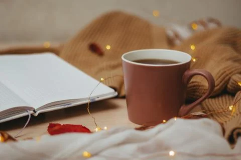 A Cup of coffee, an open diary on empty pages lie on the table, on which lies Stock Photos