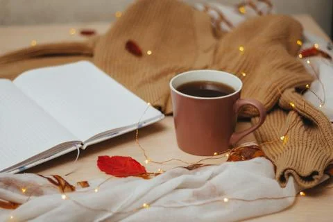 A Cup of coffee, an open diary on empty pages lie on the table, on which lies Stock Photos