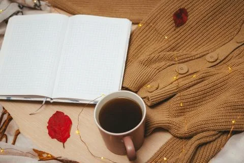 A Cup of coffee, an open diary on empty pages lie on the table, on which lies Stock Photos