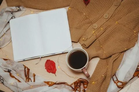 A Cup of coffee, an open diary on empty pages lie on the table, on which lies Stock Photos