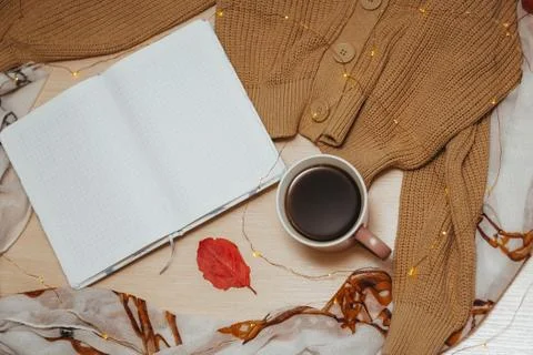 A Cup of coffee, an open diary on empty pages lie on the table, on which lies Stock Photos