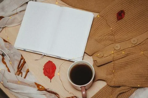 A Cup of coffee, an open diary on empty pages lie on the table, on which lies Stock Photos