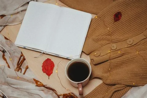 A Cup of coffee, an open diary on empty pages lie on the table, on which lies Stock Photos