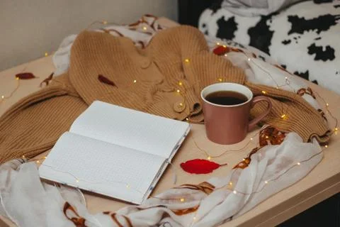 A Cup of coffee, an open diary on empty pages lie on the table, on which lies Stock Photos