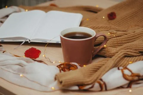 A Cup of coffee, an open diary on empty pages lie on the table, on which lies Stock Photos