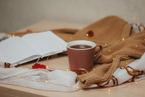 A Cup of coffee, an open diary on empty pages lie on the table, on which lies Stock Photos
