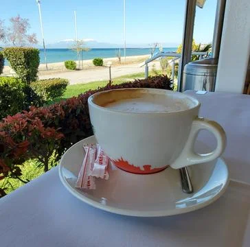 A cup of coffee or cappuccino on a table in a cafe by the sea Stock Photos