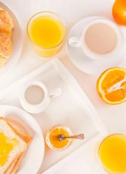 Cup of coffee or tea, bread toast with orange jam, glasses of orange juice on Stock Photos