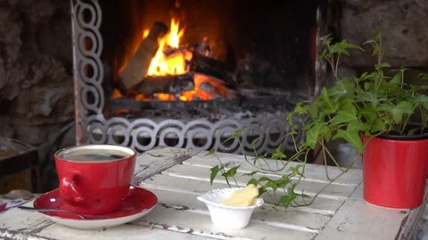 Cup Of Coffee or Tea On Table In Front Of Burning Fireplace. Stockbeeldmateriaal 105886671