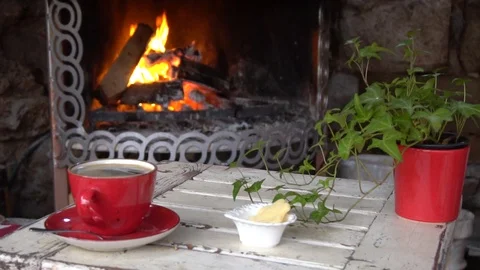 Cup Of Coffee or Tea On Table In Front Of Burning Fireplace. Vidéo 105886690