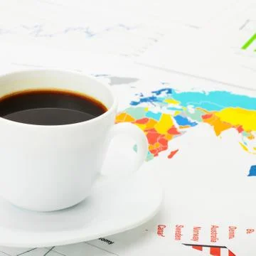 Cup of coffee over world map and financial documents 库存照片