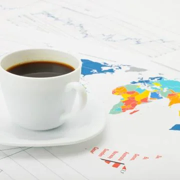 Cup of coffee over world map and financial documents - studio shot Coffee ... 写真素材