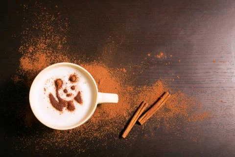Cup of coffee with panda pattern of cinnamon Stock Photos