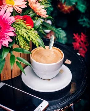 A cup of coffee with phone on the table Stock Photos