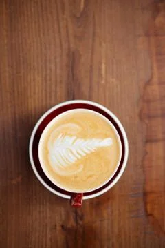 A cup of coffee in a red mug on the table. Stock Photos