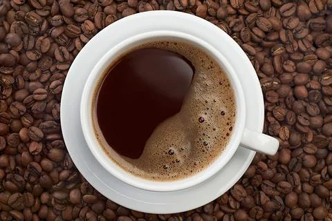 Cup of coffee on roasted beans background Stock Photos
