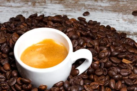 Cup of coffee on roasted beans Stock Photos