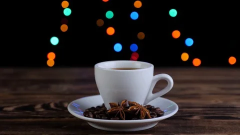 Cup of coffee with roasted coffee beans and star anise on a wooden table. Stock Footage 129592618
