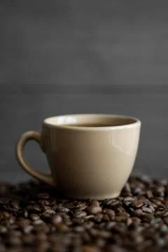 Cup of coffee with roasted coffee beans background. Mug of black coffee. Stock Photos