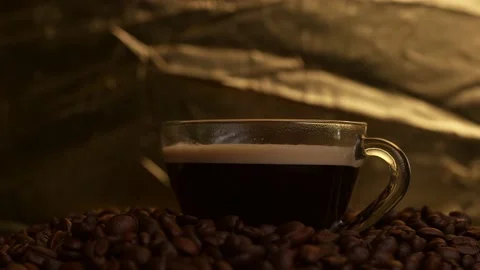 Cup Coffee Rotating on Roasted Coffee Beans Against Gold Background. 库存影片 196668910