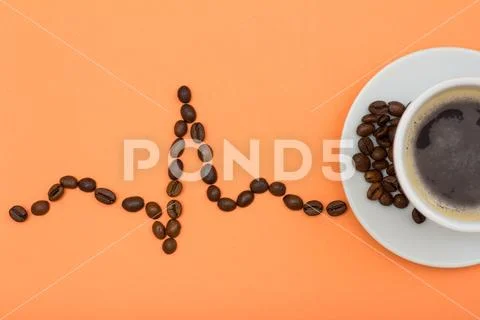 Cup of coffee on saucer with coffee beans folded in the form of a cardiogram Stock Photos