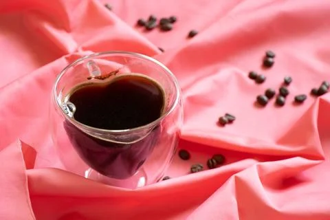 A cup of coffee in the shape of a heart on a table on a tablecloth, morning.. Stock Photos