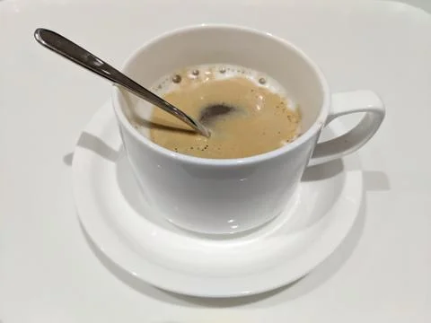 A cup of coffee with silver spoon in Stock Photos