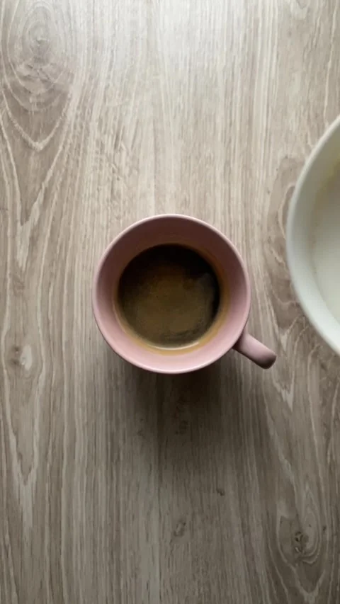 A cup of coffee sits on a wooden table Stock Footage 292016015