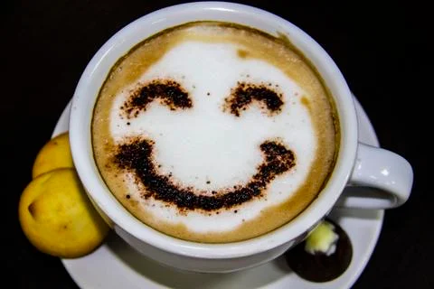 The cup of coffee with smile on the table. The biscuits with candy. Smile. Be Stock Photos