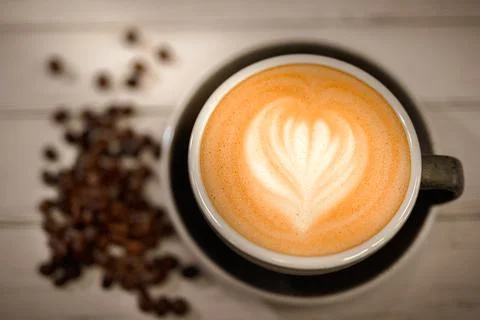 Cup of coffee soya latte art and coffee beans on old wooden background Stock Photos