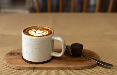 Cup of coffee, spoon and a small cake Stock Photos