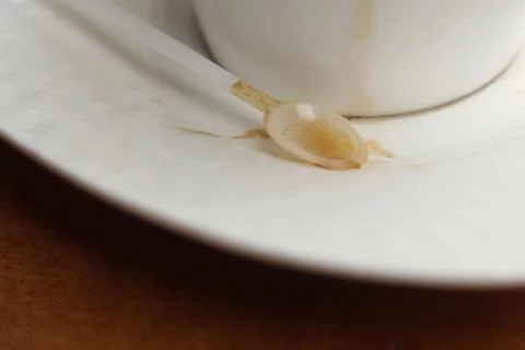 Cup of coffee with spoon on table Stock Photos