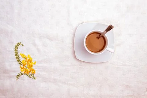 Cup of coffee with spoon on white tablecloth decorated Stock Photos