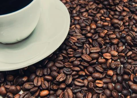 Cup of coffee standing on the grains Stock Photos