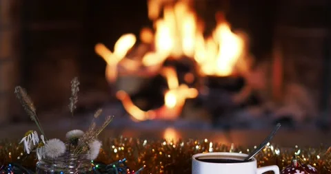 A cup of coffee stands on a decorated table against the background of a fire. Stock-Footage 161627710